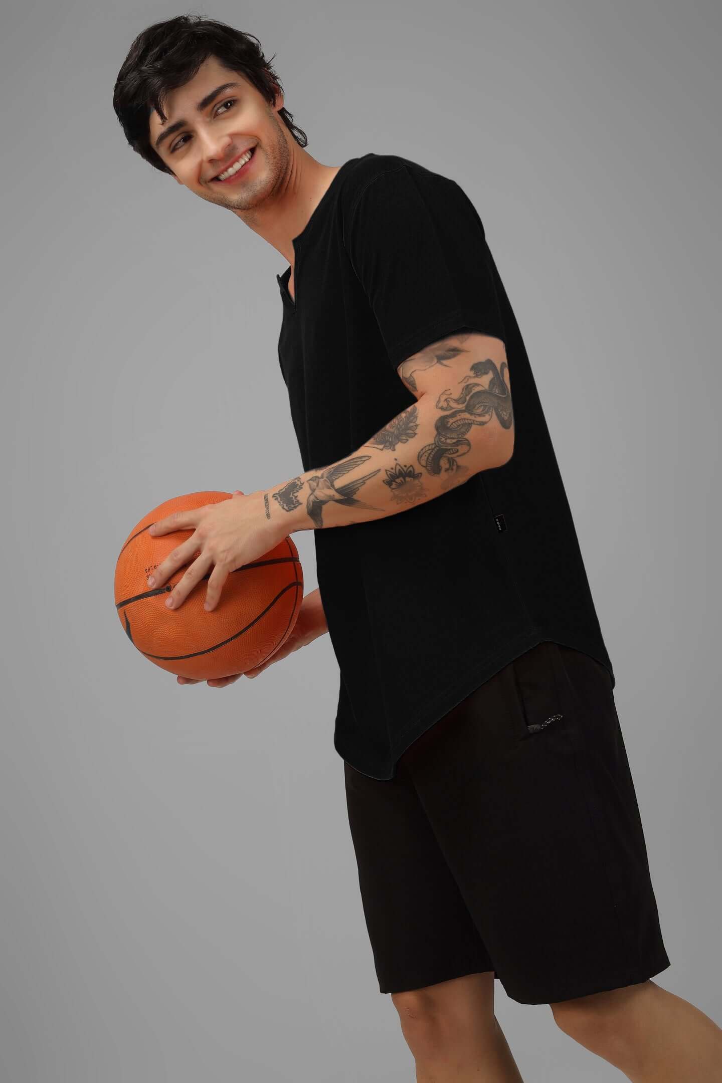 Person wearing VIKING REGULAR FIT T-SHIRT BLACK holding a basketball, showcasing timeless fashion and versatility.