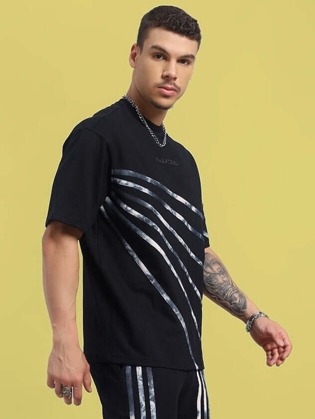 Man wearing Flicker Designer Oversized Black T-Shirt with unique metallic stripe design, featuring premium cotton fabric.