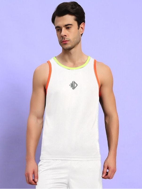 Man wearing a sleeveless white tank top and shorts against a purple background