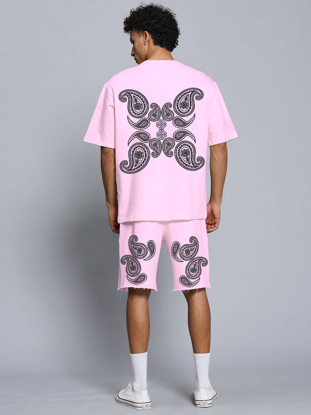 Back view of model wearing MESSI PAISLEY PRINT CO-ORD SET PINK showcasing oversized paisley patterns on pink fabric.