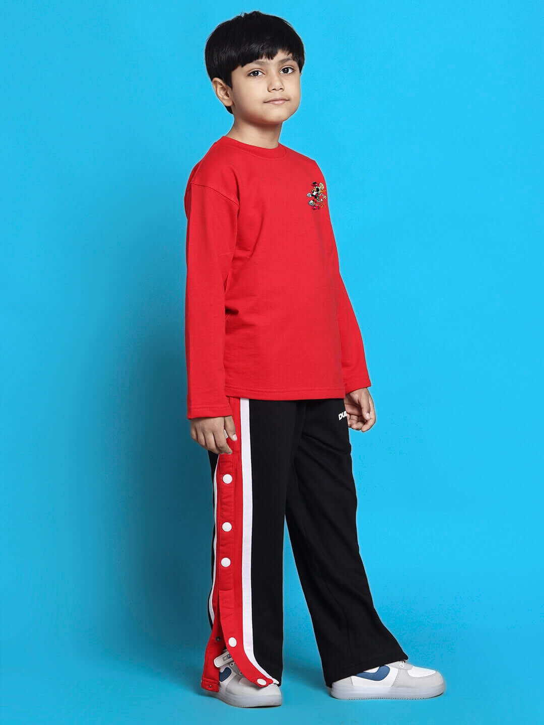 Child wearing MICKEY CO-ORD FOR BOYS GIRLS RED BLACK, featuring Mickey Mouse design, red top, and black pants against blue background.