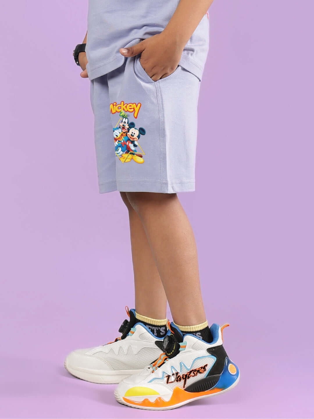 Child wearing MICKEY DINGO SHORTS FOR BOYS & GIRLS LAVENDER with colorful sneakers.