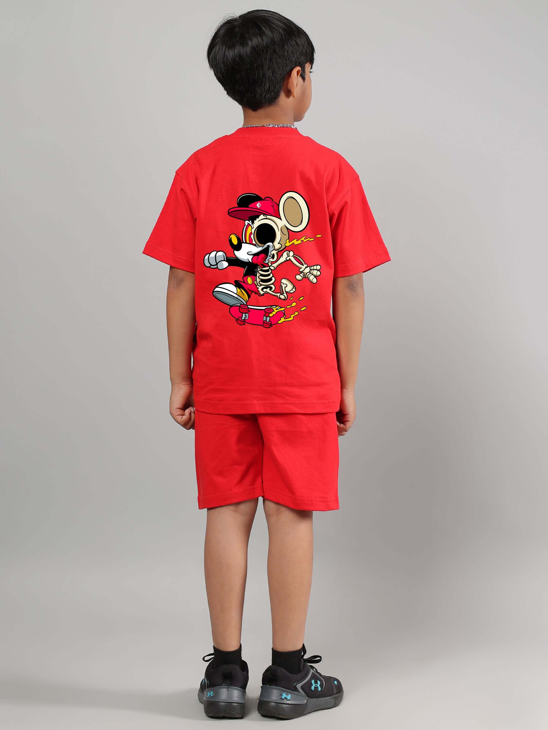 Boy wearing a red Mickey summer co-ord set for kids by DUDS; back view displaying fun cartoon graphic.