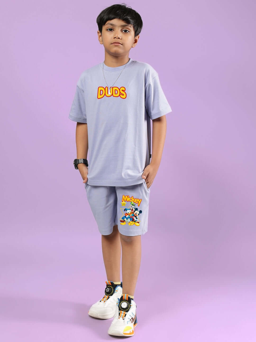 Child wearing lavender Mickey Dingo co-ord for boys & girls by DUDS, featuring T-shirt and shorts with Mickey design on purple background.