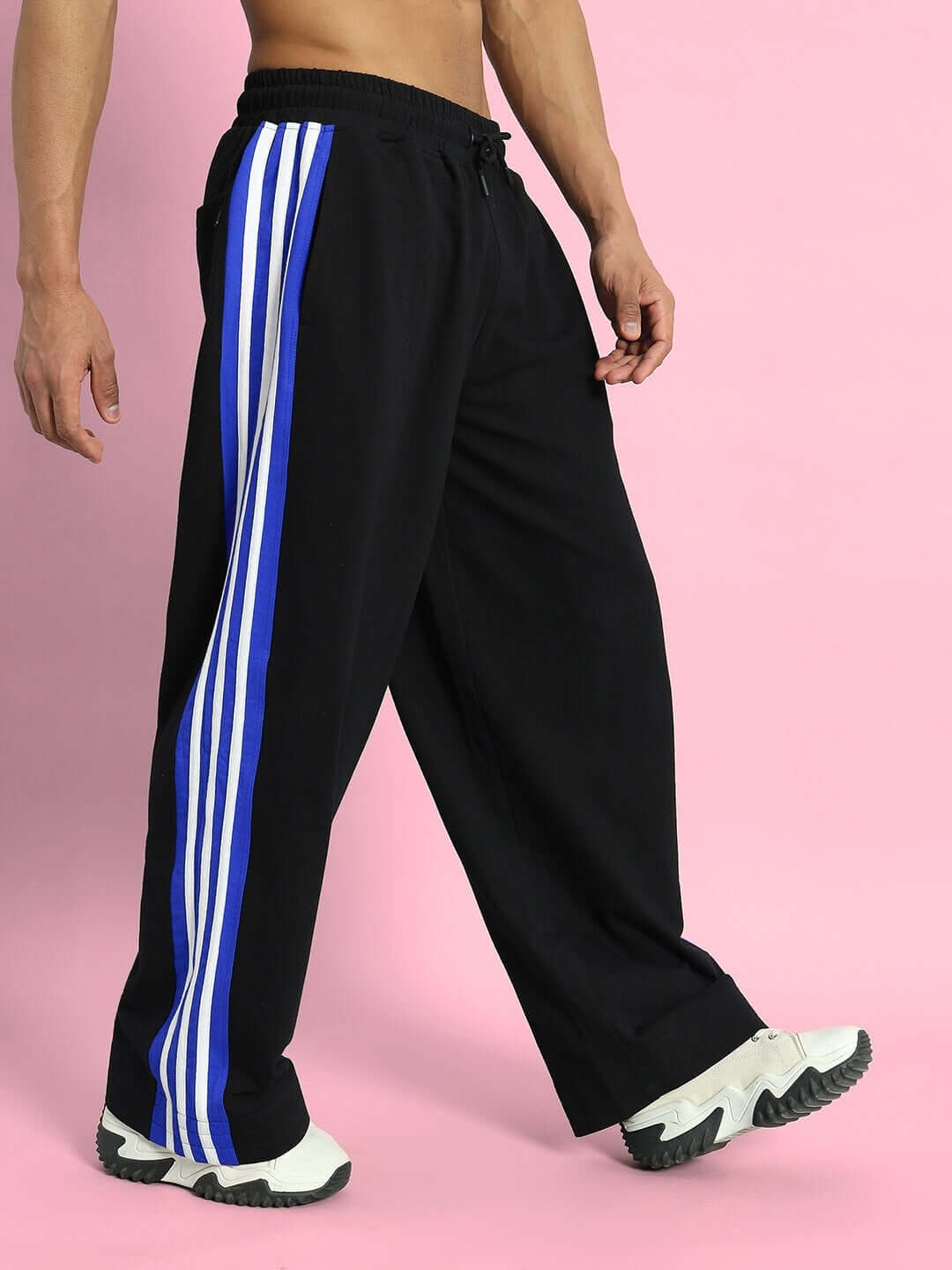 MILANO RELAXED-FIT JOGGERS BLACK-BLUE Model wearing Milano Relaxed-Fit Joggers in black-blue with side stripes, showcasing comfortable sports fashion by DUDS.