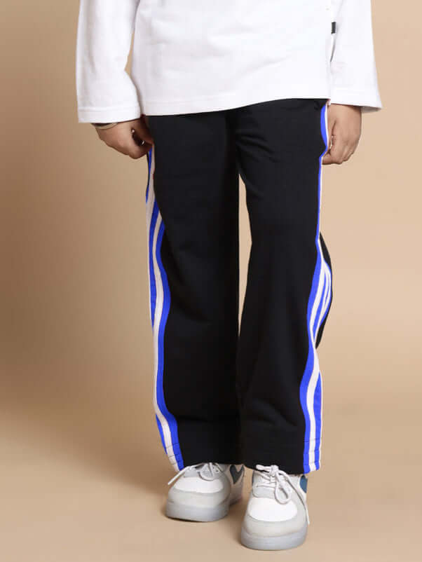 Child wearing Milano relaxed black-blue jogger pants by DUDS, featuring side stripes, suitable for both boys and girls.