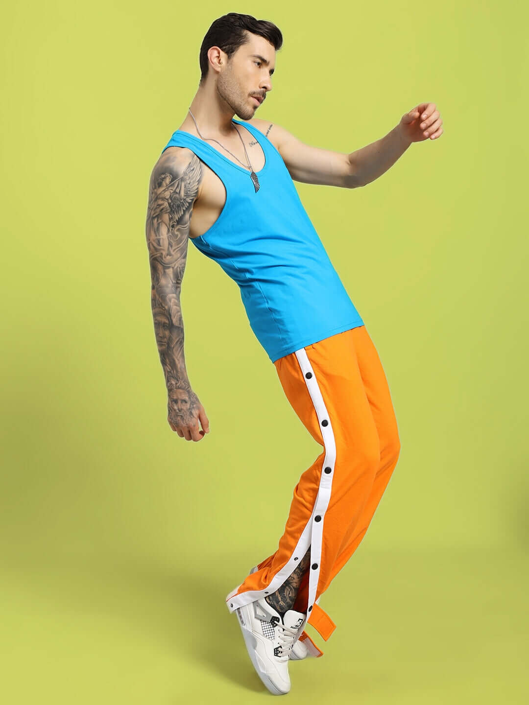 Man wearing Miller Relaxed Fit Joggers Orange, showcasing comfortable and stylish streetwear in a dynamic pose.
