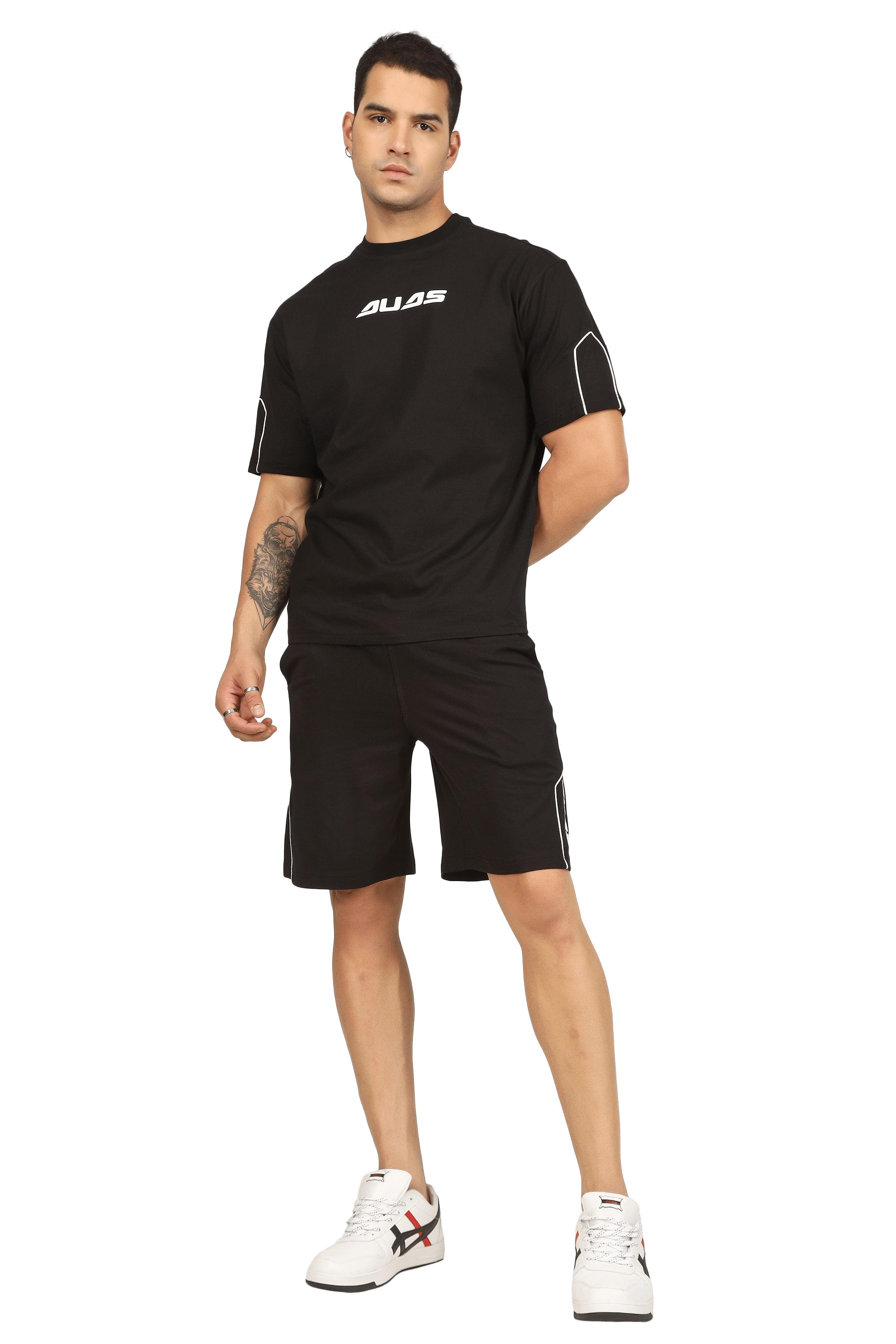 Man wearing black DUDS Minimal Shaped Cord Co-Ord Set with casual sneakers, showcasing a stylish and comfortable fashion choice.