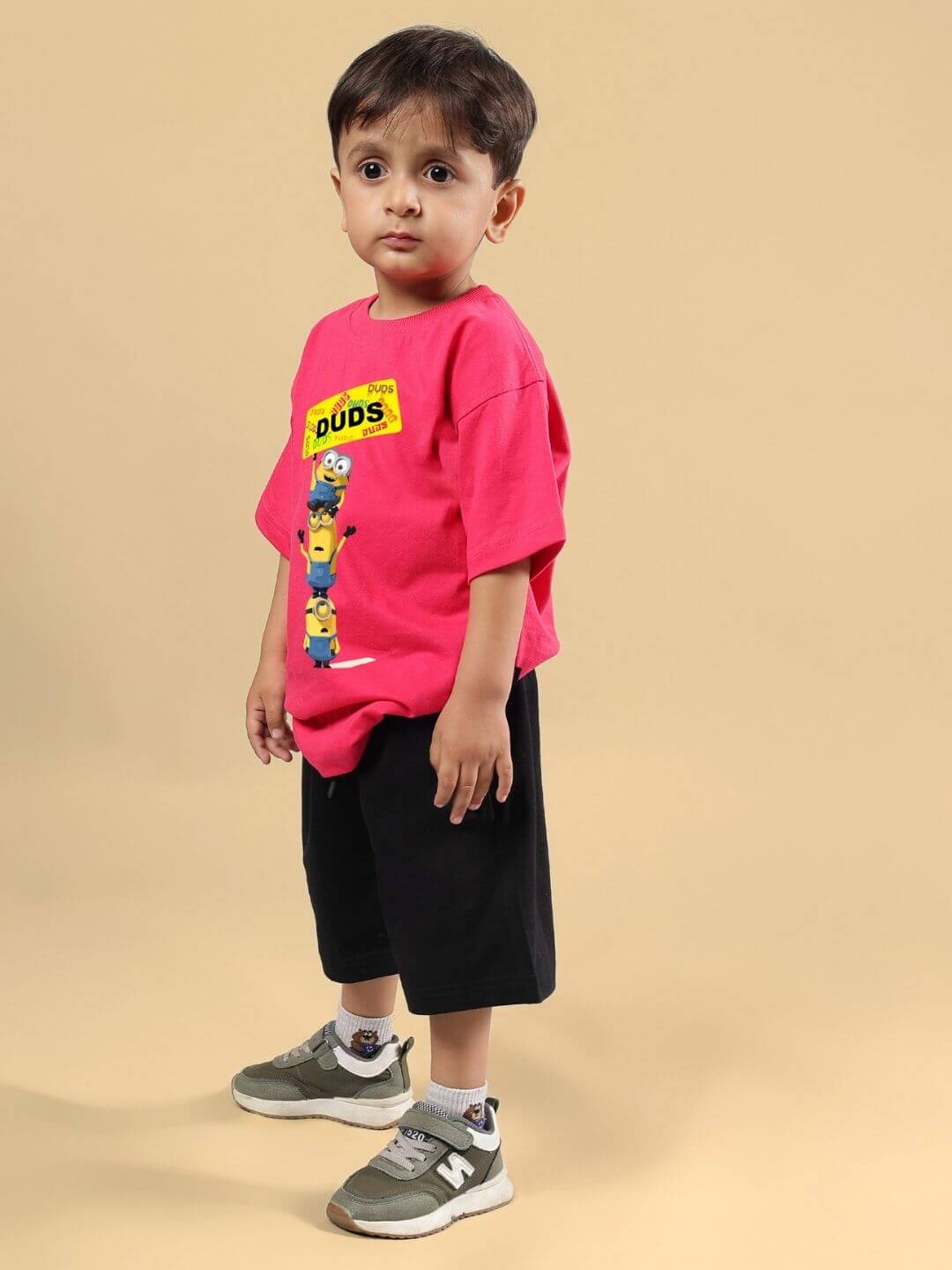 Child wearing Minion Cartoon Co-ord for Boys and Girls Pink-Black outfit with minion graphic on a pink shirt and black shorts.
