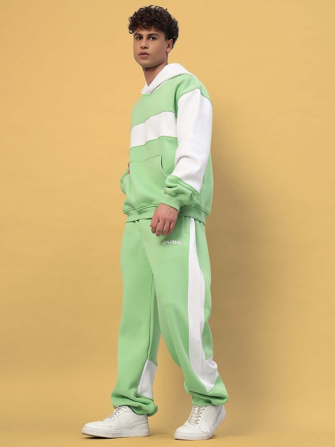 Model wearing MINTED BLISS FLEECE COLORBLOCK CO-ORD GREEN WHITE hoodie and joggers, showcasing modern streetwear style