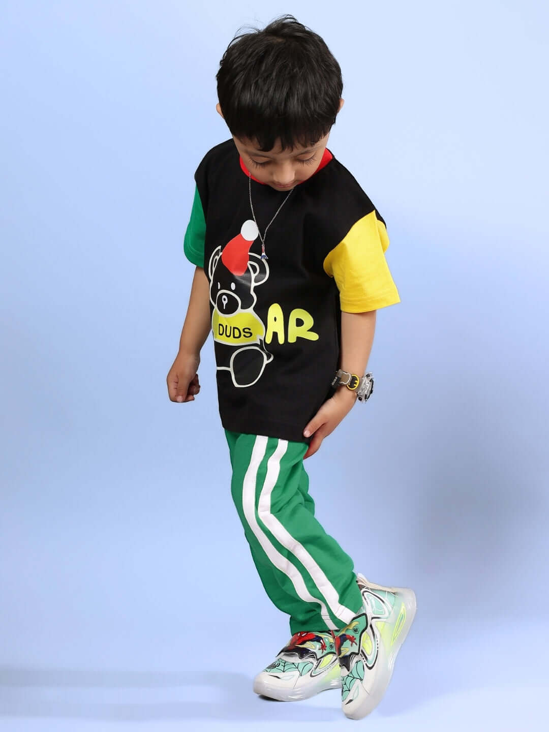 Child wearing MOCHA CO-ORD FOR BOYS & GIRLS BLACK GREEN outfit with colorful shirt and green pants.