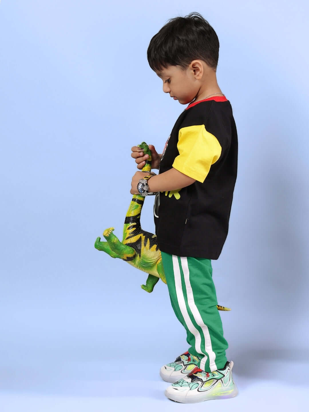 Child wearing MOCHA CO-ORD FOR BOYS & GIRLS BLACK GREEN with dinosaur toy, showcasing casual fashion.