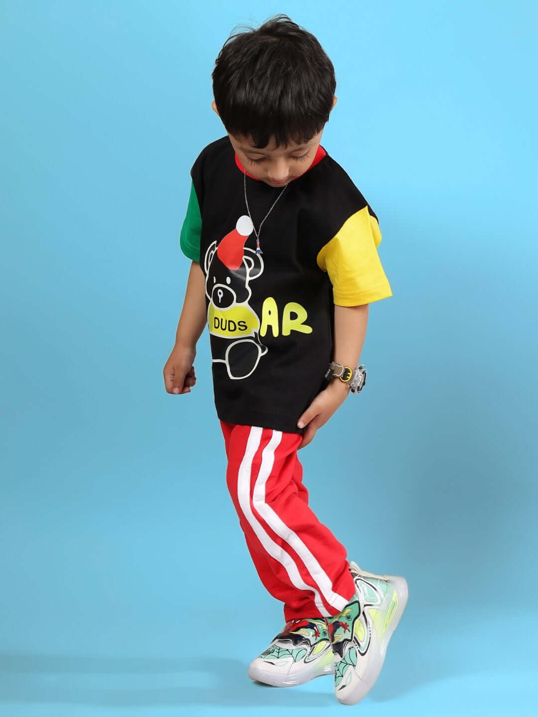 Child wearing MOCHA CO-ORD FOR BOYS & GIRLS BLACK RED, stylish outfit with red stripes and graphic tee on blue backdrop