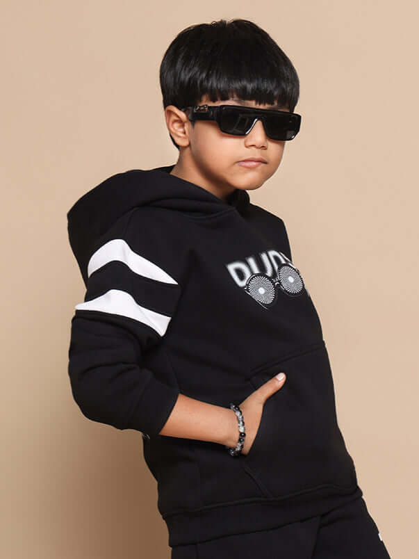 Young boy wearing a MOLLY oversized black hoodie with sunglasses, styled by DUDS, showcasing a cool and trendy fashion look.