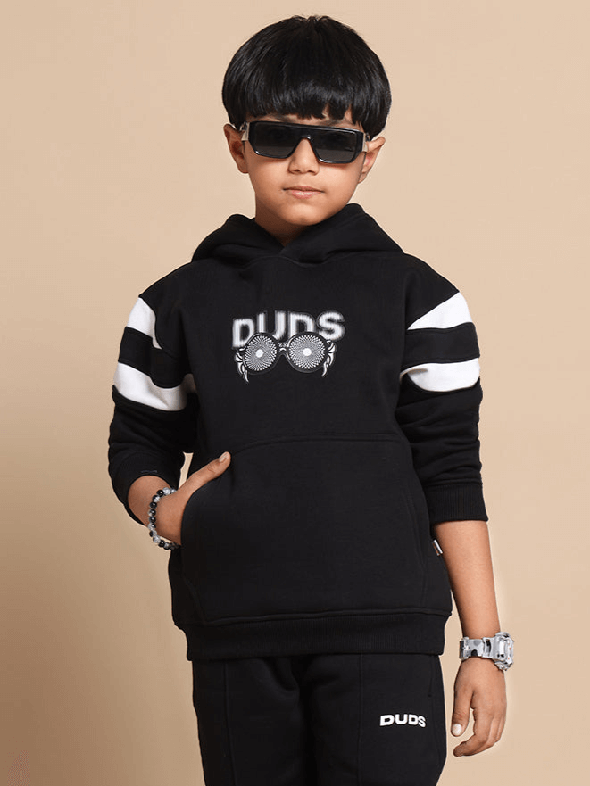 Child wearing black MOLLY oversized hoodie by DUDS, featuring white stripes and "DUDS" logo, available for custom fit.