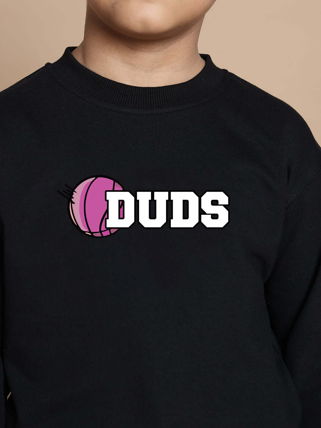 Child wearing black oversized basketball sweatshirt with pink ball and "DUDS" graphic print.