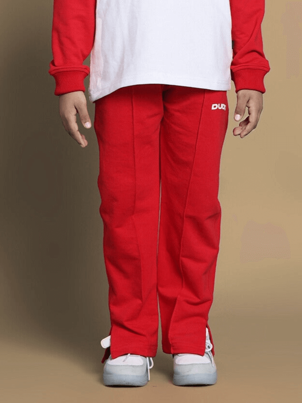 Child wearing red Mortimer jogger pants, suitable for boys and girls, by DUDS.