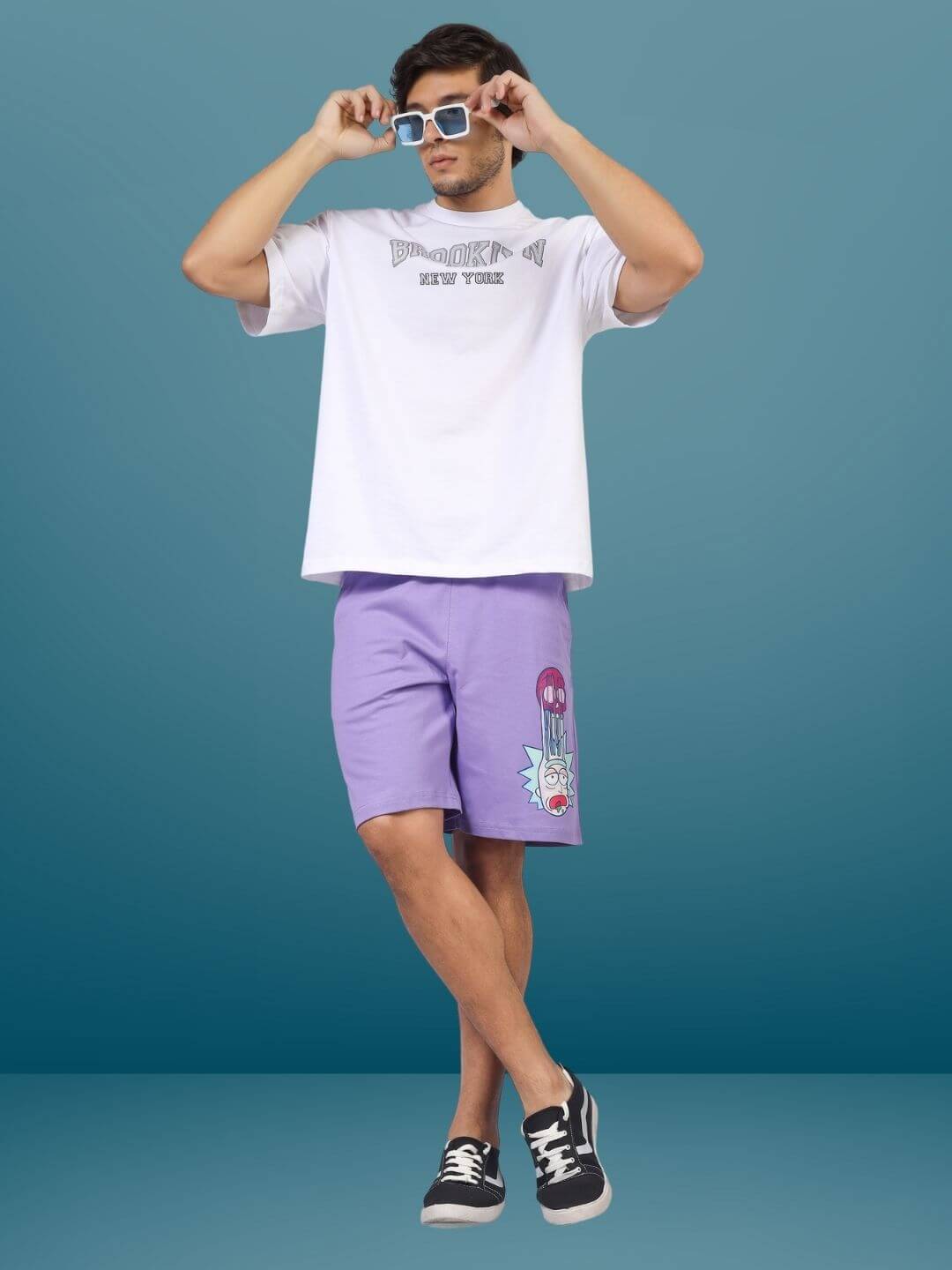 Man wearing lavender Morty-Fied regular fit shorts with graphic design, styled with a white t-shirt and sunglasses.