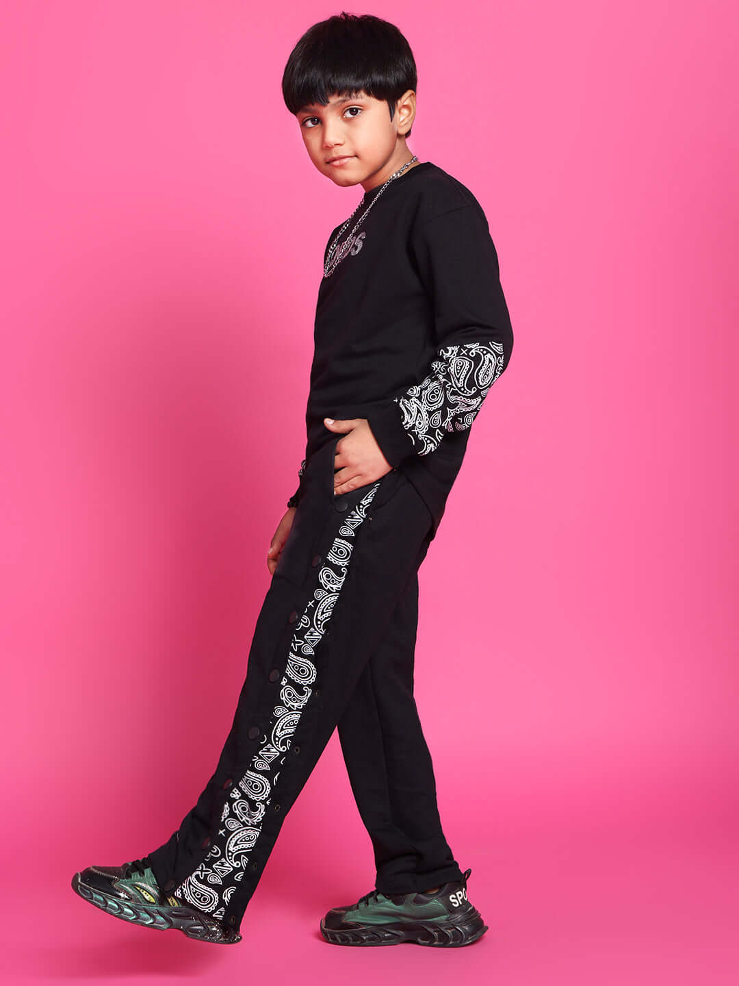 Child wearing MOTIF CO-ORD black outfit for boys and girls, featuring intricate patterns, suitable for custom fit options.