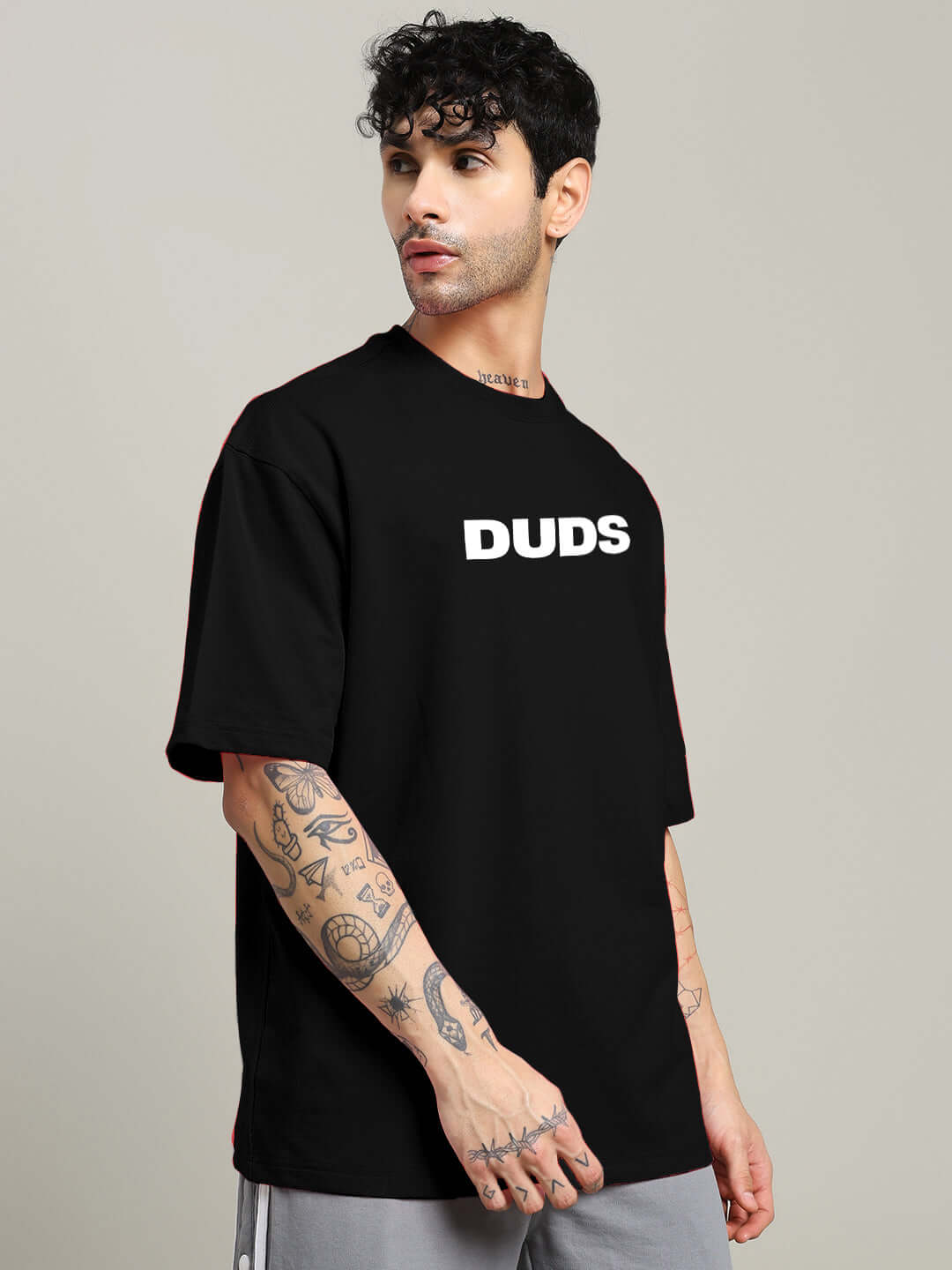 Alt Tag: Man wearing a MOTION DROP OVERSIZED T-SHIRT BLACK with graphic print, showcasing streetwear style and relaxed fit.