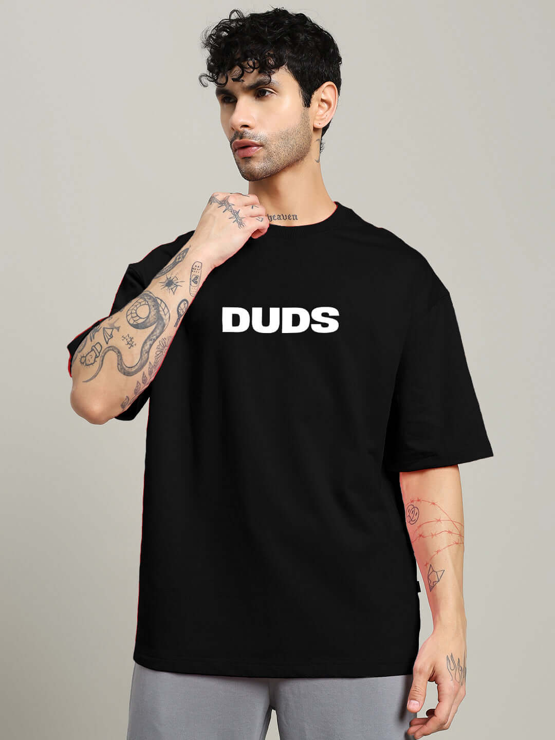 Model wearing MOTION DROP OVERSIZED T-SHIRT BLACK with DUDS logo, showcasing streetwear style and comfort.