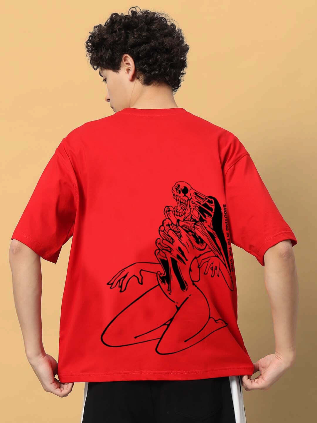 Person wearing a red oversized t-shirt with black Mudflap Girl design, showcasing unique handmade fashion.