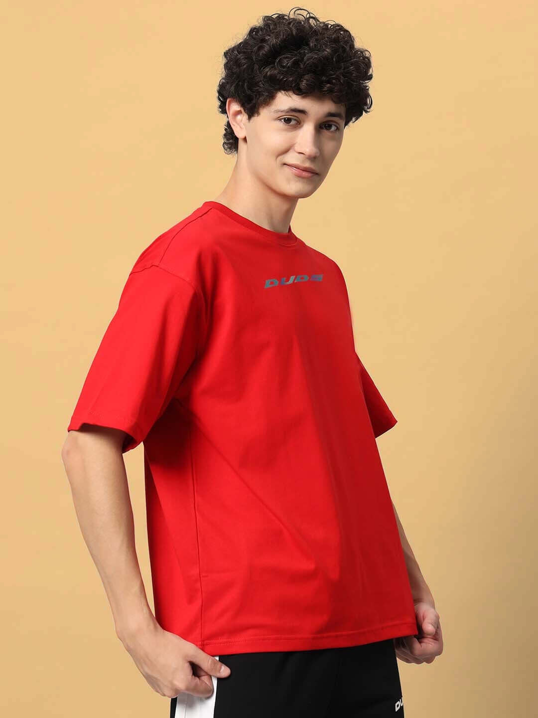 Man wearing DUDS red oversized T-shirt showcasing Mudflap Girl design, available in customizable sizes for a perfect fit.