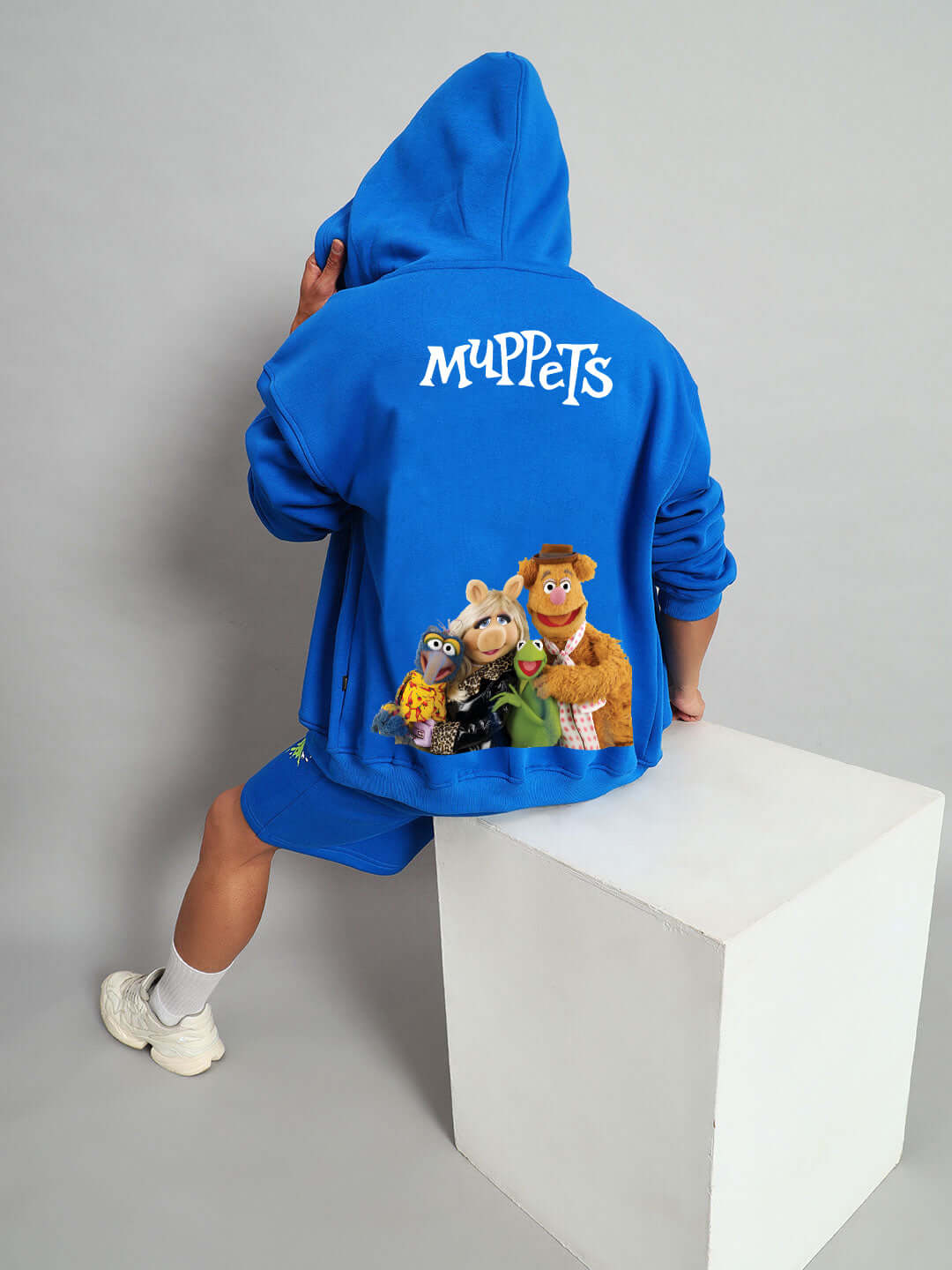 Person wearing blue MUPPET fleece co-ord with iconic character graphic on the back, highlighting creative design by DUDS.