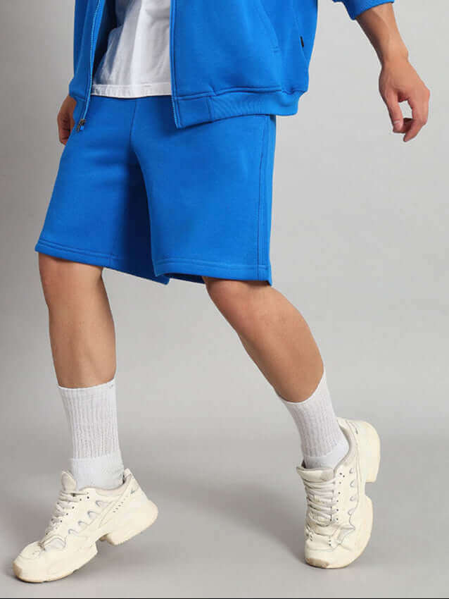 Person wearing Muppet Duds Fleece Co-ord in Blue with white sneakers.