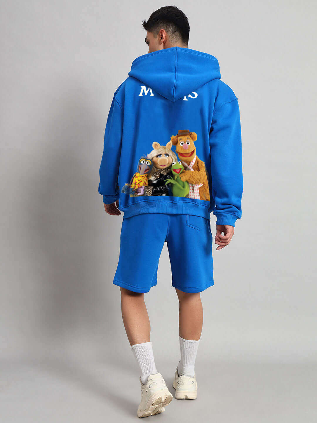 Person wearing Muppet Duds Fleece Co-ord in Blue with character graphic on back, showcasing casual style and comfort.