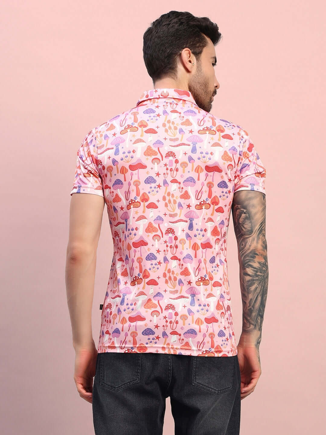 Back view of a pink multi-colored mushroom print regular fit t-shirt made from sports polyester fabric, modeled by a person.