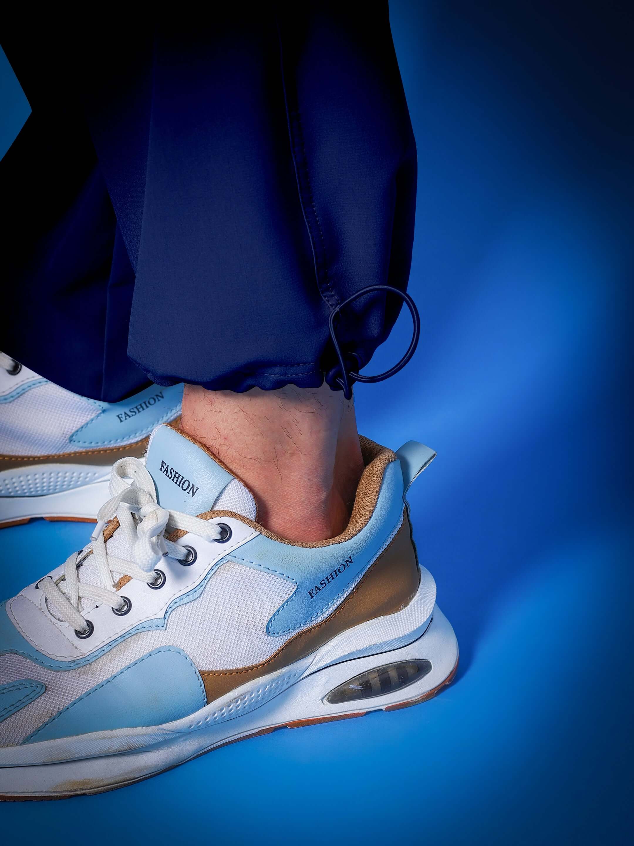 Close-up of MYRIAD RELAXED FIT CARGO PANTS NAVY BLUE paired with trendy white sneakers.