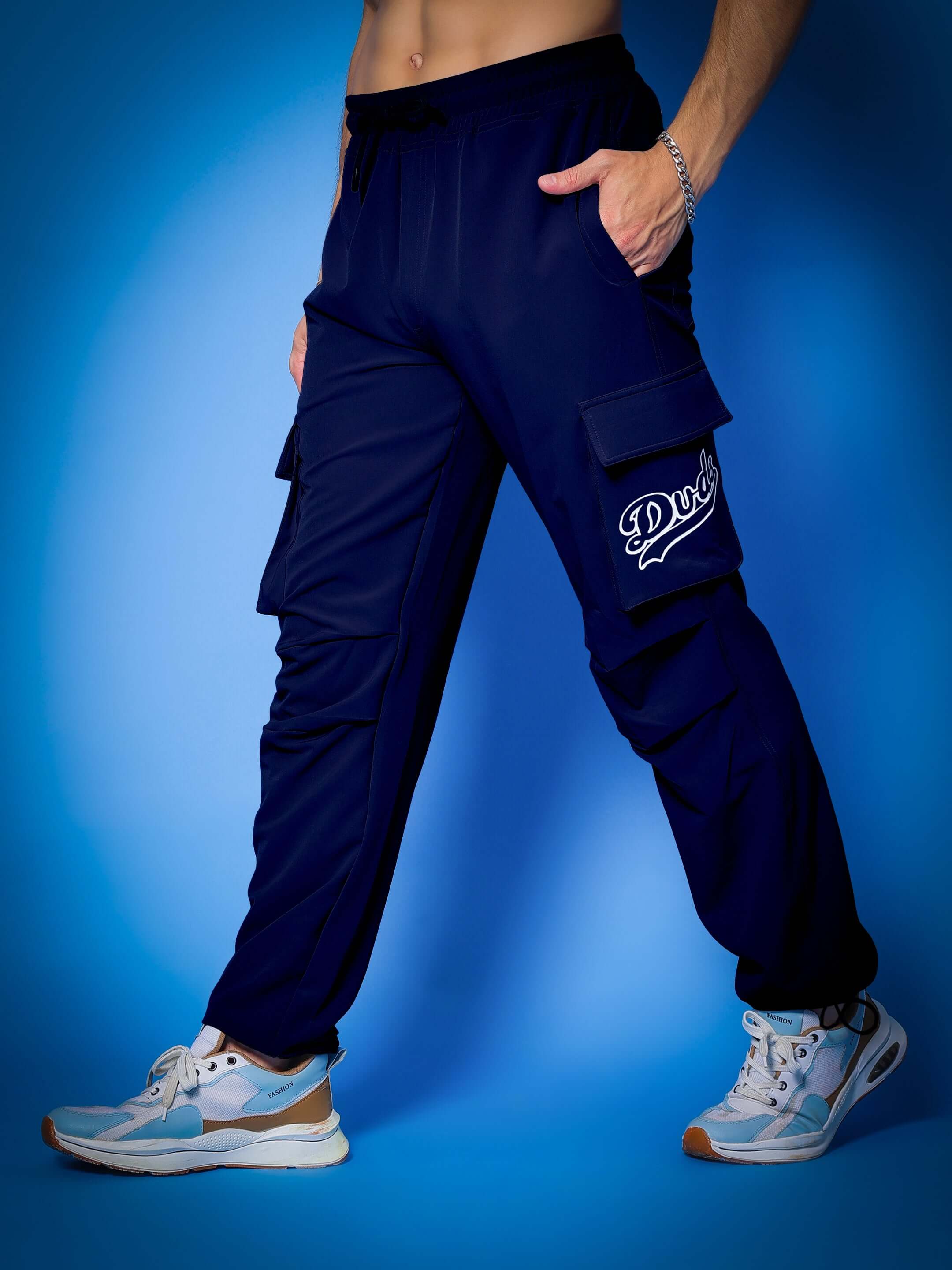 Model wearing navy blue Myriad Relaxed Fit Cargo Pants by Duds, showcasing versatile style and comfort with a custom fit option.