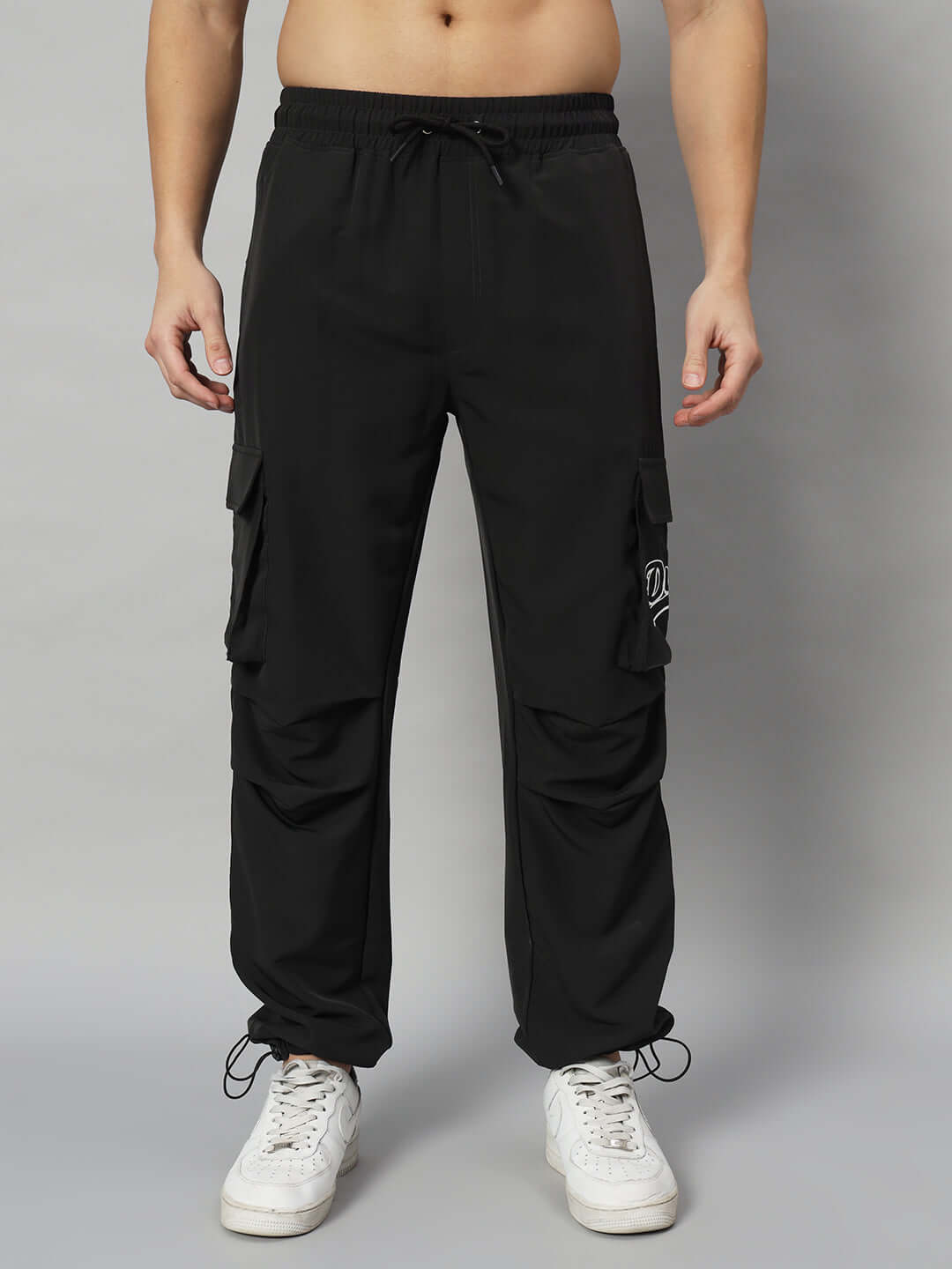 Black relaxed fit cargo pants with pockets, worn by model, customizable for size, available from DUDS with handmade quality.