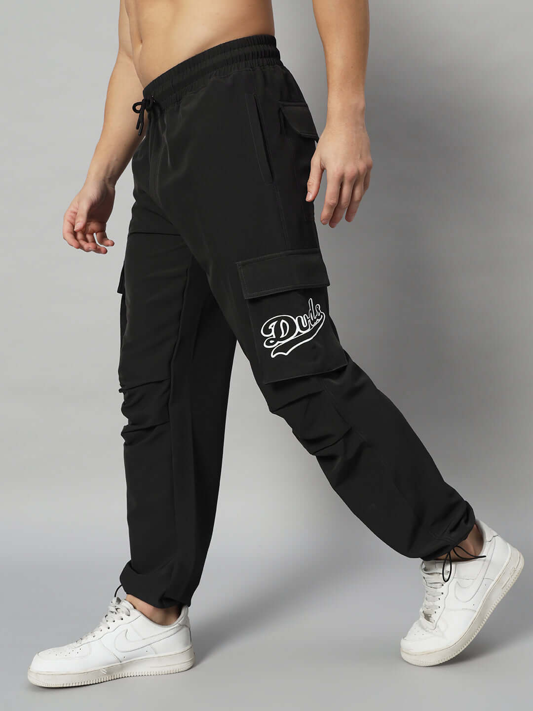 MYRIAD Relaxed Fit Black Cargo Pants, customizable size option, shown on a model wearing white sneakers, available from DUDS.