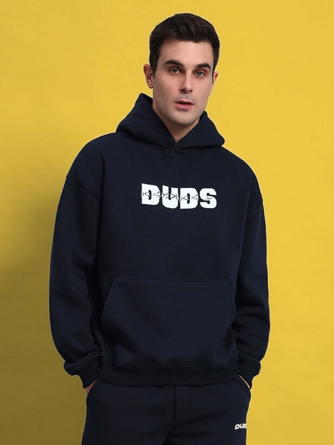Navy blue Fight Night fleece hoodie with logo, worn by model against a yellow background.