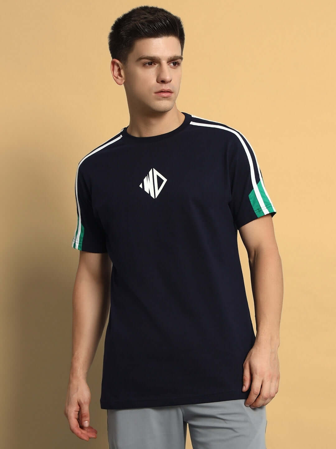 Man wearing PRIMA Regular T-Shirt in navy blue with green stripes, made of premium cotton French terry, styled casually.