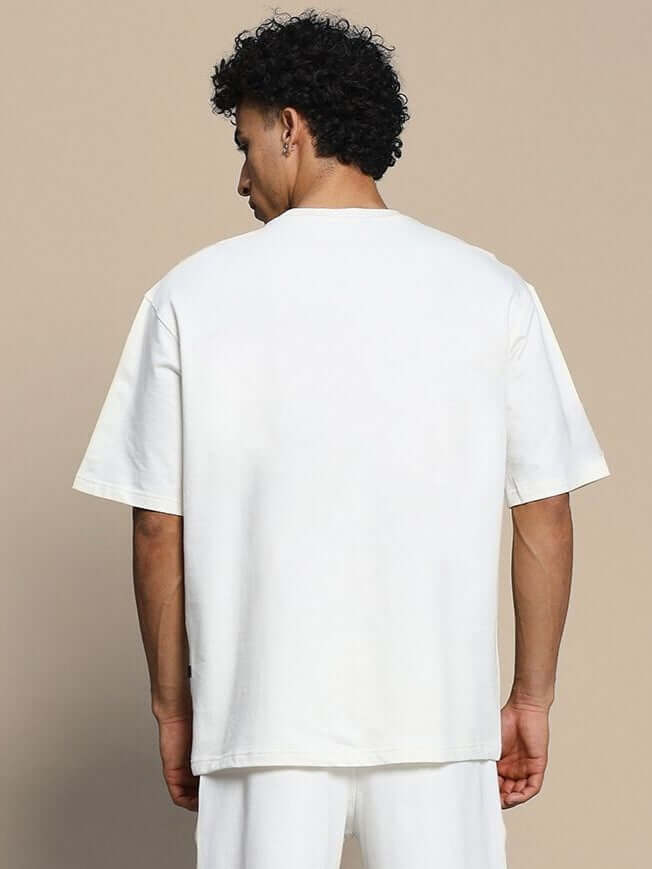 Back view of Neo Classic Skull Over-Sized T-Shirt Off White worn by a male model, showcasing the relaxed fit and minimalist design.