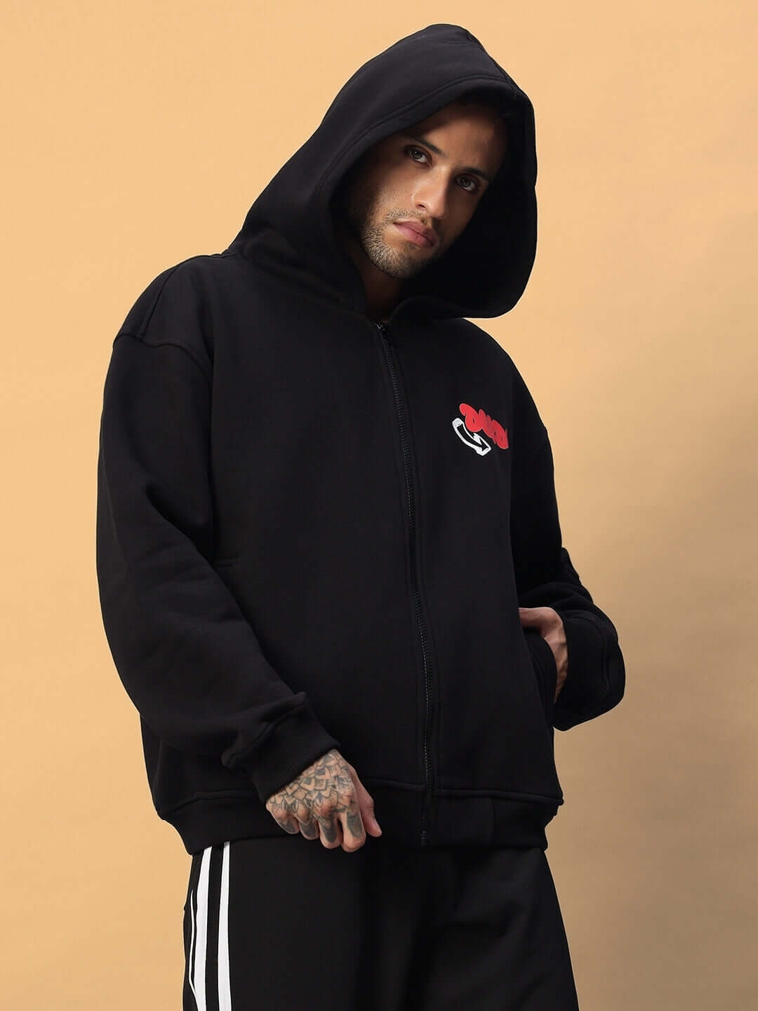 Man wearing NEVER BE AFRAID FLEECE HOODIE BLACK with hood up, featuring empowering graphic and premium fleece fabric, street-ready style.