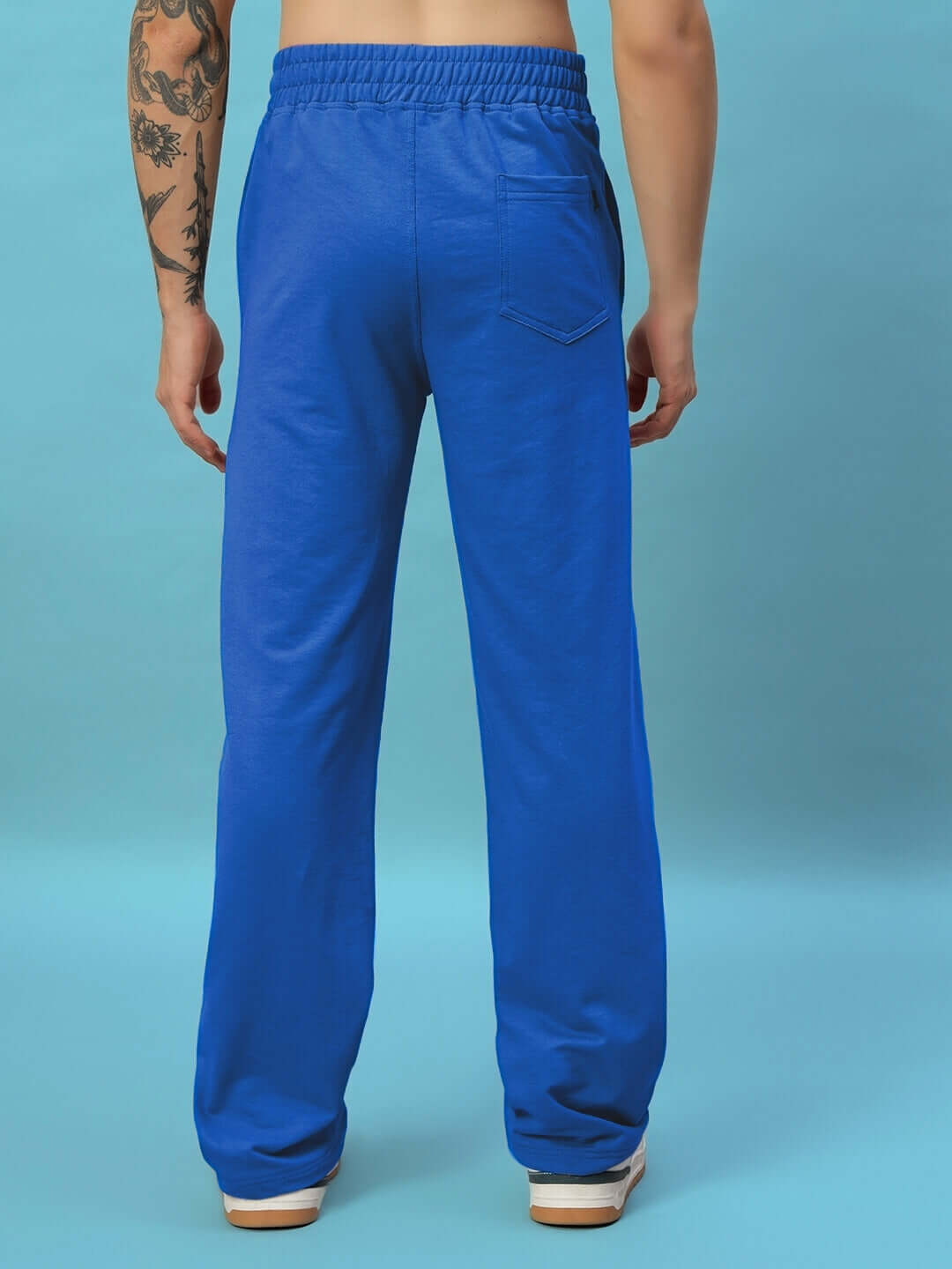 Back view of a person wearing NEW ERA RELAXED FIT JOGGERS ROYAL BLUE, showcasing the relaxed fit and vibrant color.