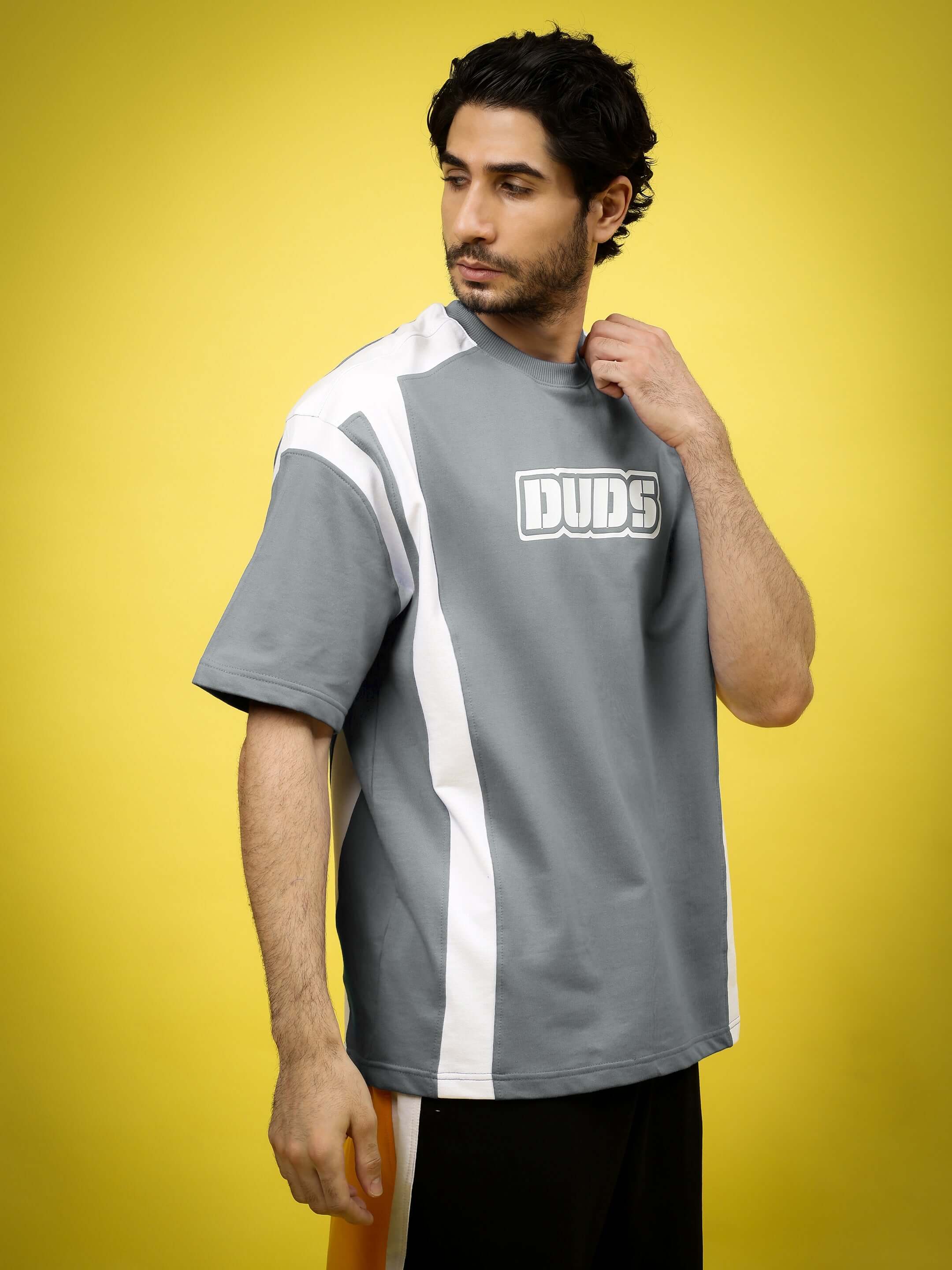 Man wearing a NINJA STORM OVER-SIZED T-SHIRT GREY with graphic print against yellow background