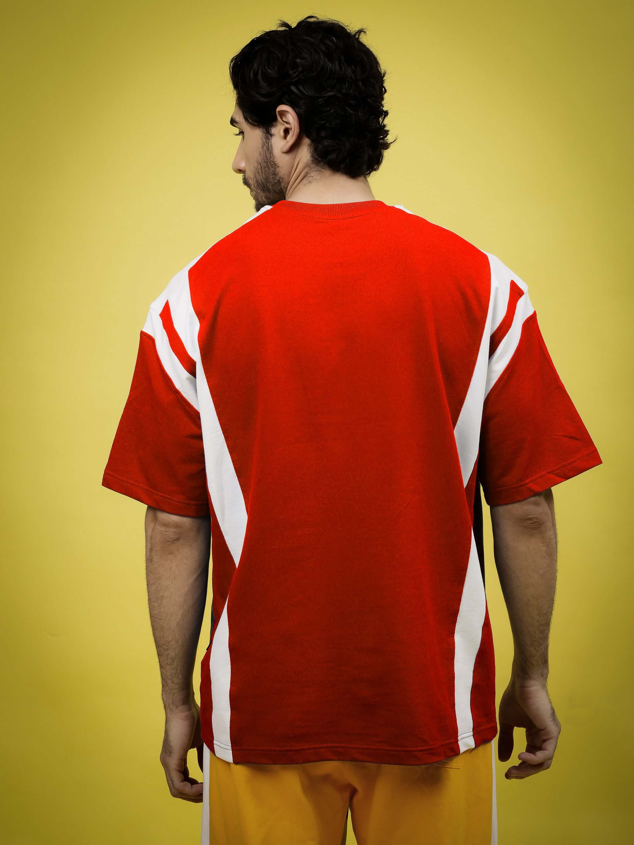 Back view of model wearing NINJA STORM OVER-SIZED T-SHIRT RED with white accents on yellow background.