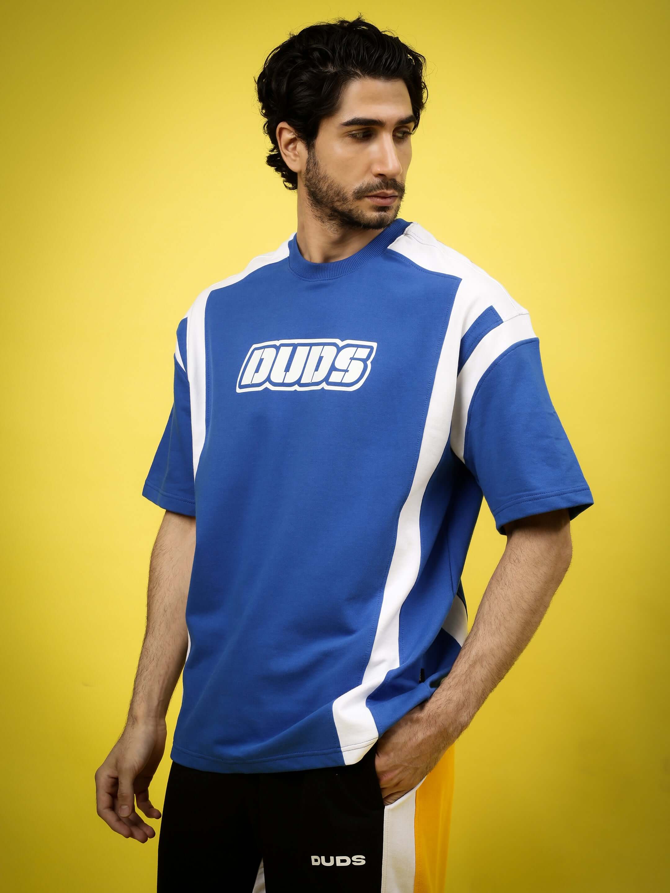 Model wearing a royal blue Ninja Storm oversized T-shirt with logo, made of premium cotton French terry, from Color By Colours, India.