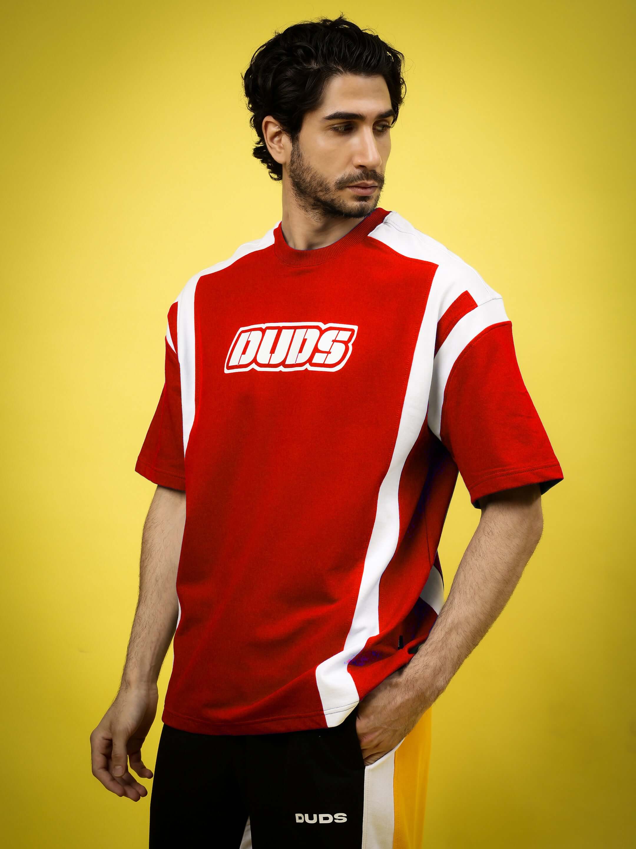 Ninja Storm oversized red T-shirt in premium cotton blend, featuring bold white accents, worn by a male model against a yellow background.