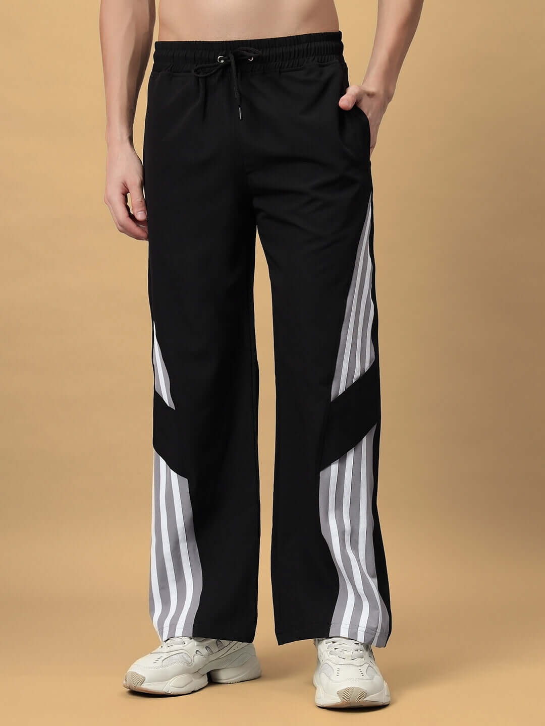 Model wearing NITRO Relaxed Fit Cargo Pants in black with custom fit option, available for prepaid orders, featuring striped design.