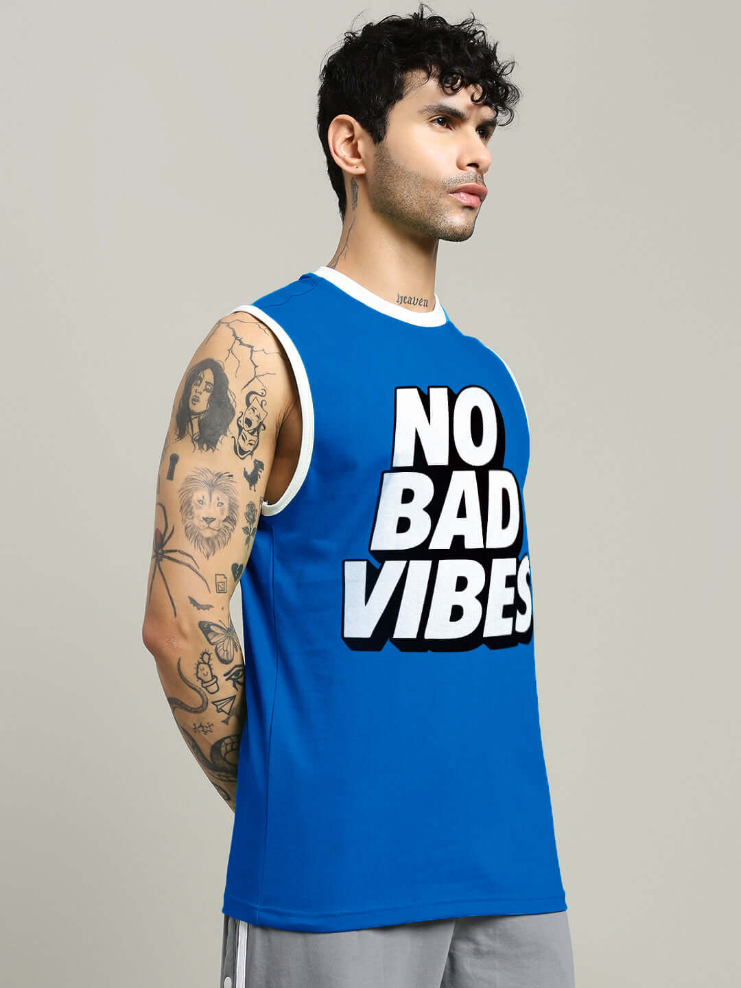 Man wearing a blue 'NO BAD VIBES' gym t-shirt, showcasing custom fit design options for personalized size preferences.