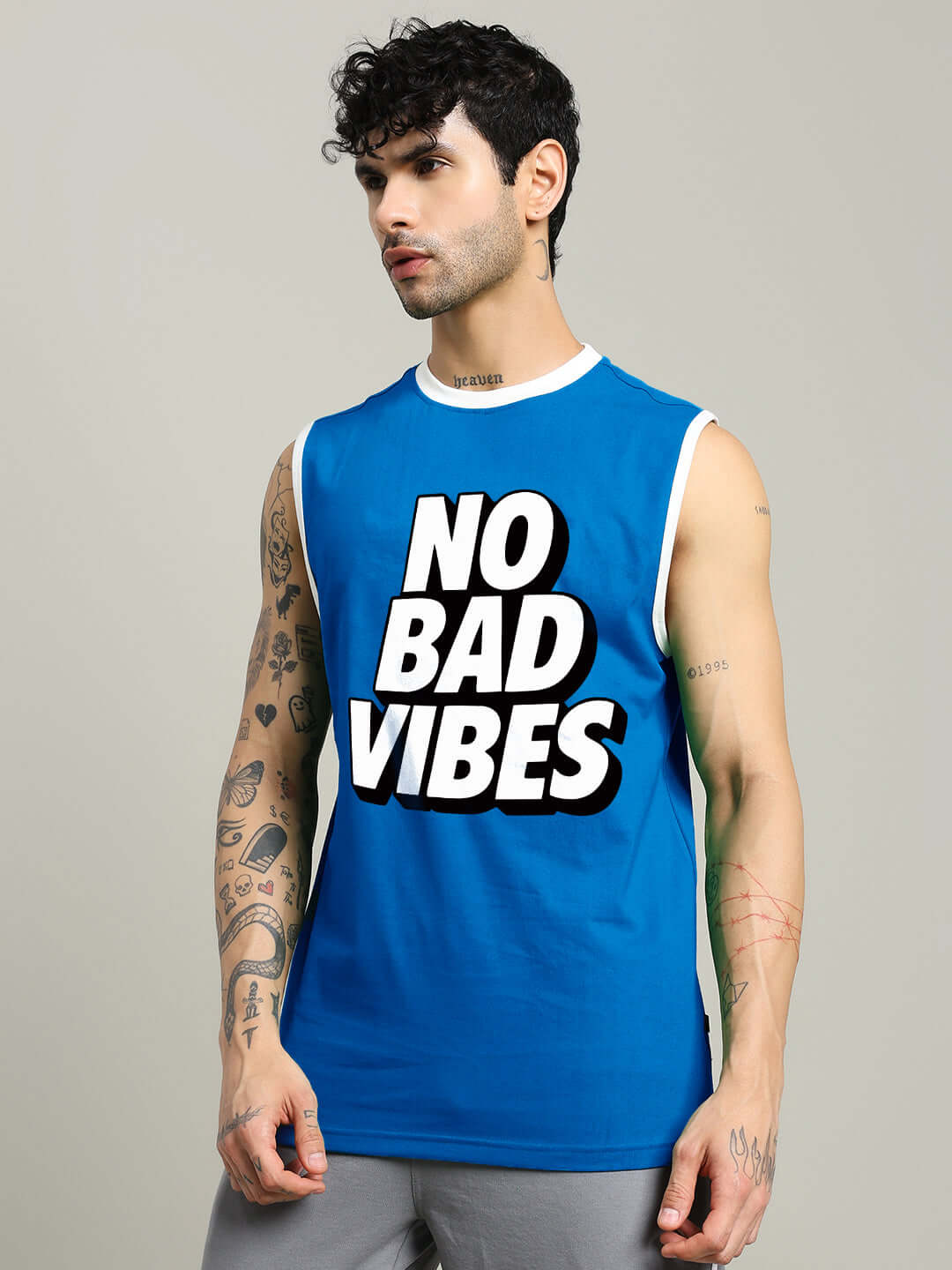 Man wearing blue No Bad Vibes gym t-shirt with tattoos, available in custom fit, ideal for workouts and positive vibes.