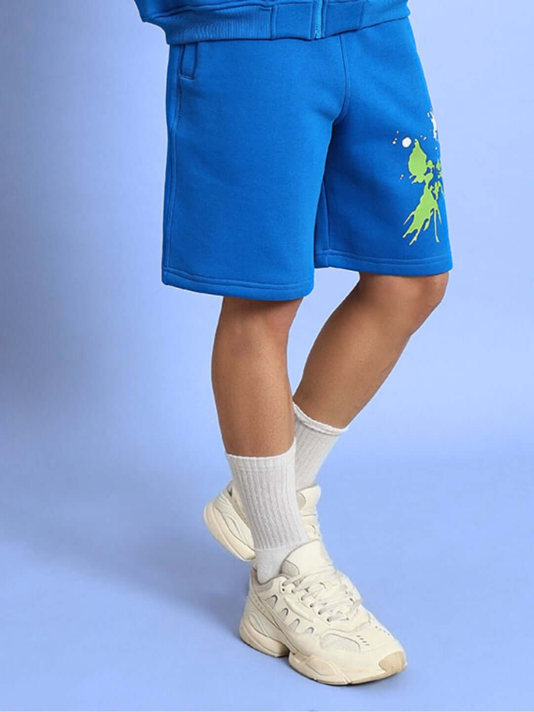 NO DRAMA COTTON FLEECE SHORTS ROYAL BLUE with elastic waistband and side pockets, worn with white sneakers and socks.