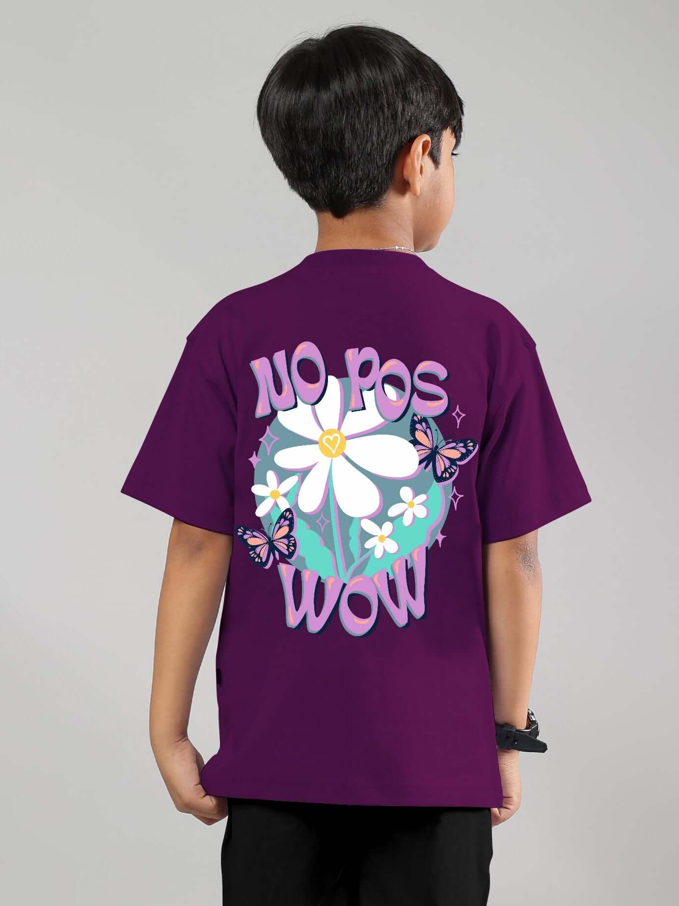 Boy wearing a purple 'NO POS WOW' t-shirt with floral and butterfly design, suitable for boys and girls. Made by DUDS.