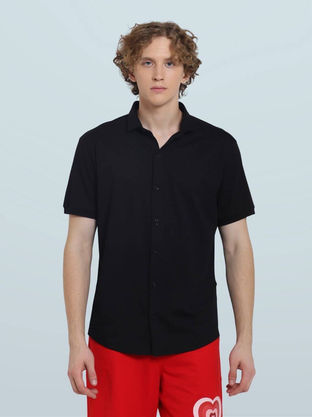 Model wearing Noir black half-sleeve shirt, slim fit, 100% cotton Lycra, wrinkle-free, on a light background. Ideal for all-day wear.